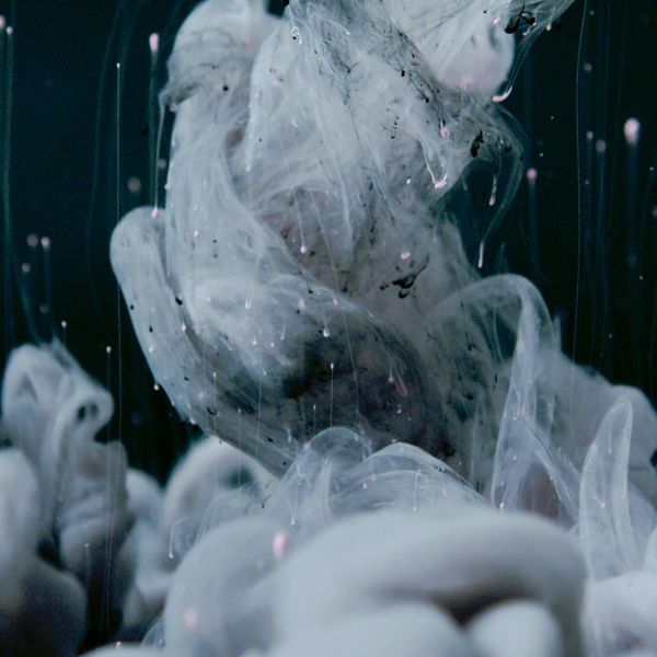 Abstract image of a person in fluid motion against a dark background.